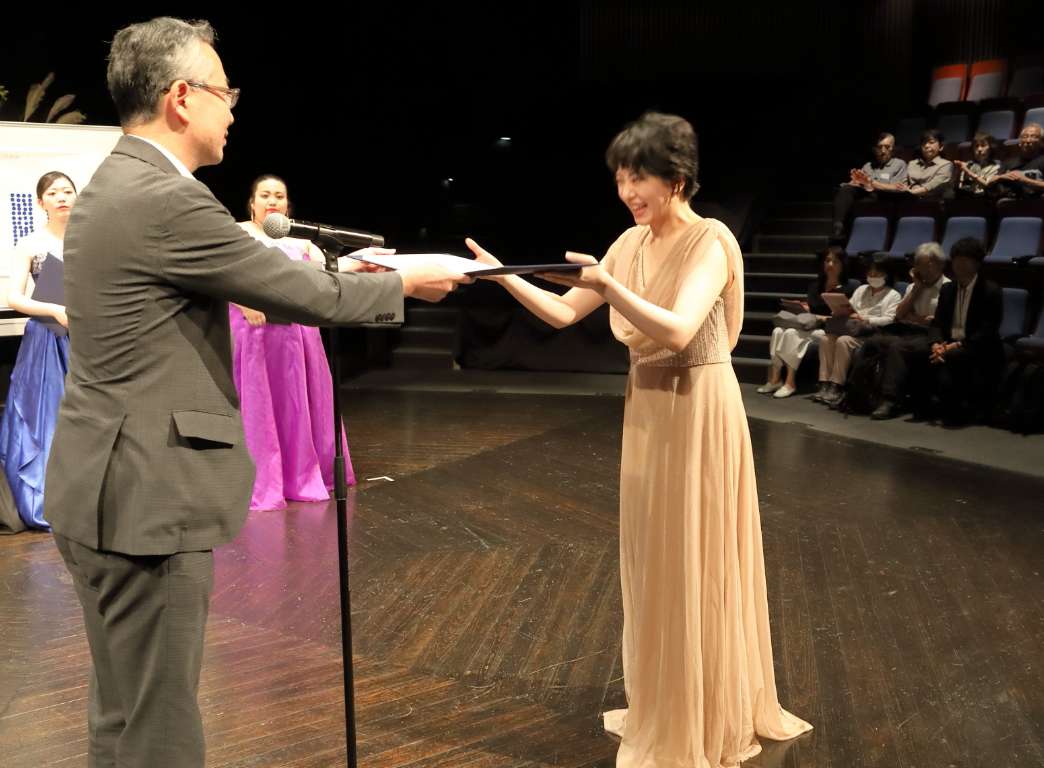 実行委員 平田一之氏からピアノ 小野田知華さんへ奨励賞を授与