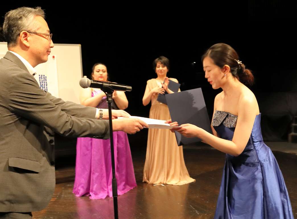 実行委員 平田一之氏からピアノ 酒井志野さんへ名古屋市文化振興事業団賞を授与 